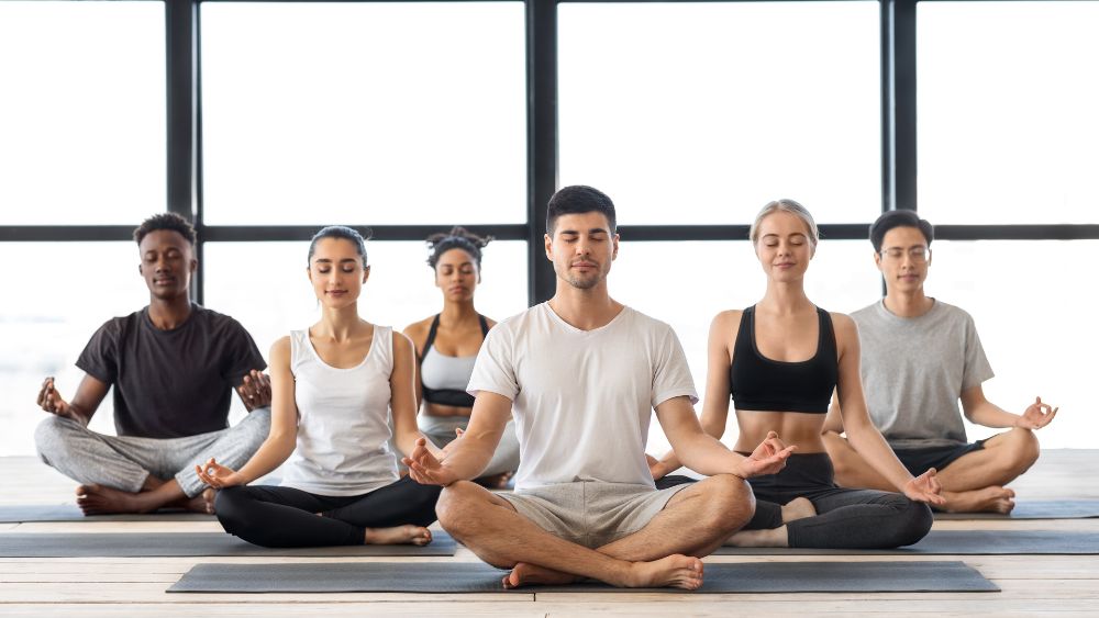 Gruppo di ragazzi esegue una sessione di yoga - Yoga e longevità